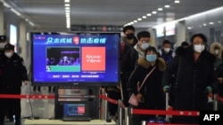 Travelers pass through a fever detection system developed by Chinese search engine Baidu, at the Qinghe railway station, in Beijing, China, Feb. 6, 2020.