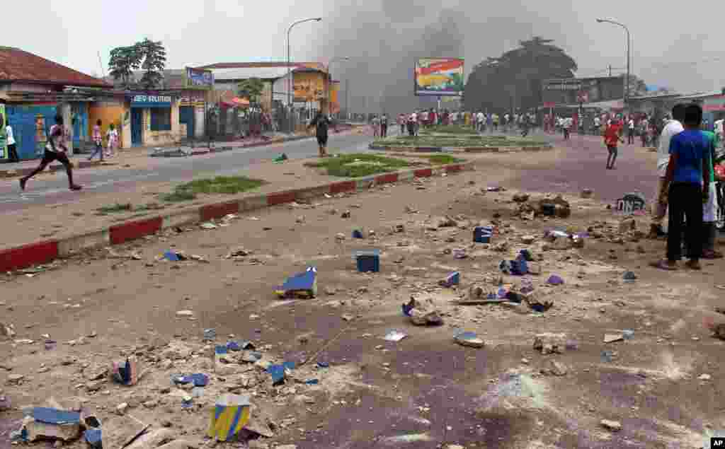 Des peirres sont visibles dans une rue principale pendant que des manifestants brûlent des pneus lors d&#39;une manifestation contre une nouvelle loi qui pourrait retarder l&#39;élection prévue pour 2016 àKinshasa, République démocratique du Congo, le lundi 19 janvier 2015,