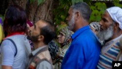 People queue up at a polling booth to cast their vote in Naira, south of Srinagar, Indian-controlled Kashmir, Sept. 18, 2024. 