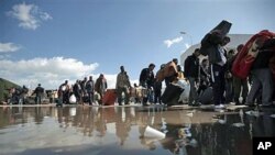 People carry their belongings after they fled Libya at the Tunisia-Libya border, near the village of Ras Ajdir, Tunisia, February 24, 2011