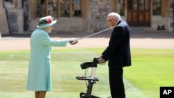 Captain Sir Thomas Moore, who raised 39 million pounds ($53 million) for health service charities by walking laps of his Bedfordshire garden, receives his knighthood from Britain's Queen Elizabeth at Windsor Castle in Windsor, England, July 17, 2020.