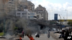 Para pengunjuk rasa membakar ban untuk memblokir jalan di Beirut, Lebanon, Senin, 8 Maret 2021. 