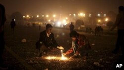 Warga India menyalakan lilin dekat Istana Kepresidenan di New Delhi, India, Sabtu (22/12). Polisi menggunakan gas air mata dan meriam air untuk membubarkan massa yang berusaha masuk ke istana saat menyuarakan tuntutan keadilan bagi korban pemerkosaan di bus oleh sekelompok anggota gang di kota tersebut.