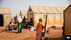 FILE - Displaced women prepare food in the Kaya camp, 100 kms north of Ouagadougou, Burkina Faso, Feb. 8, 2021.