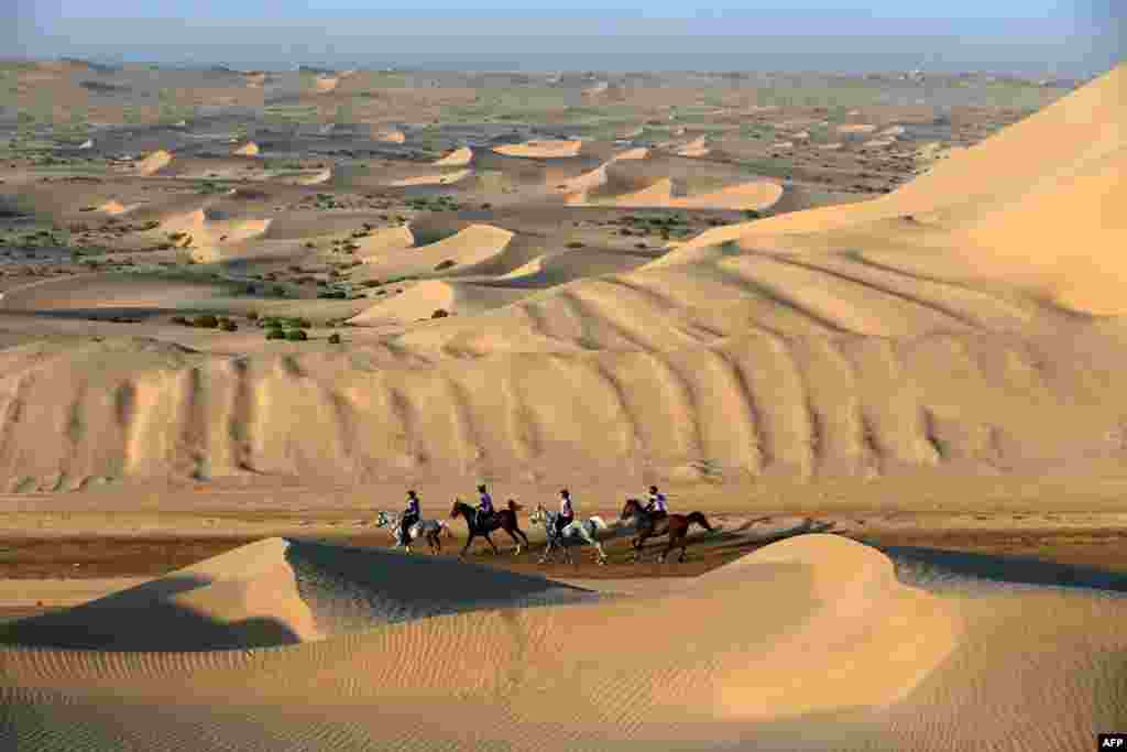 Para penunggang kuda melintasi bukit-bukit pasir dalam festival Balap Kuda Sheikh Sultan Bin Zayed al-Nahyan di Boudthib Endurance Village dekat Abu Dhabi, ibu kota Uni Emirat Arab.