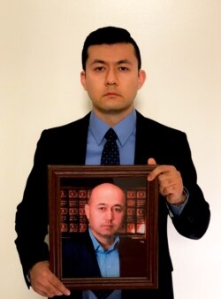 Kamalturk Yalqun holds a picture of his father, Yalqun Rozi, in Philadelphia in 2019. (Photo courtesy of Kamalturk Yalqun)