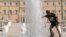 FILE - A boy cools himself in a fountain of the central Syntagma square in front of the Greek parliament during a hot day in Athens, Friday, July 14, 2023. 