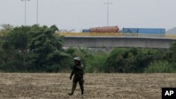 A fuel tanker, cargo trailers and makeshift fencing are used as barricades by Venezuelan authorities attempting to block humanitarian aid entering from Colombia on the Tienditas International Bridge, Feb. 6, 2019.