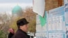 A man reads election candidates posters during parliamentary election in Tashkent, Uzbekistan, Dec. 22, 2019.