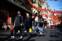 A man wearing a protective face mask walks in Chinatown district, in London, March 2, 2020.