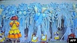 Seorang peserta karnival menunggu di depan kostum karnival pada malam kedua Karnival Rio di Sambadrome di Rio de Janeiro, Brazil, 12 Februari 2018 (foto: AFP Photo/Carl de Souza)