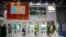 A visitor wearing a face mask walks past a display from the U.S. Soybean Export Council at the China International Import Expo in Shanghai, Nov. 5, 2020.