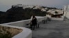 A tourist sits at Firostefani as Greek authorities are taking emergency measures in response to intense seismic activity on the popular Aegean Sea holiday island of Santorini, southern Greece, Feb. 3, 2025.