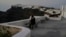 A tourist sits at Firostefani as Greek authorities are taking emergency measures in response to intense seismic activity on the popular Aegean Sea holiday island of Santorini, southern Greece, Feb. 3, 2025.
