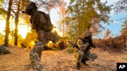 In this photo taken from video released by the Russian Defense Ministry's press service on Sept. 19, 2024, Russian servicemen fire toward Ukrainian positions at an undisclosed location in Ukraine.