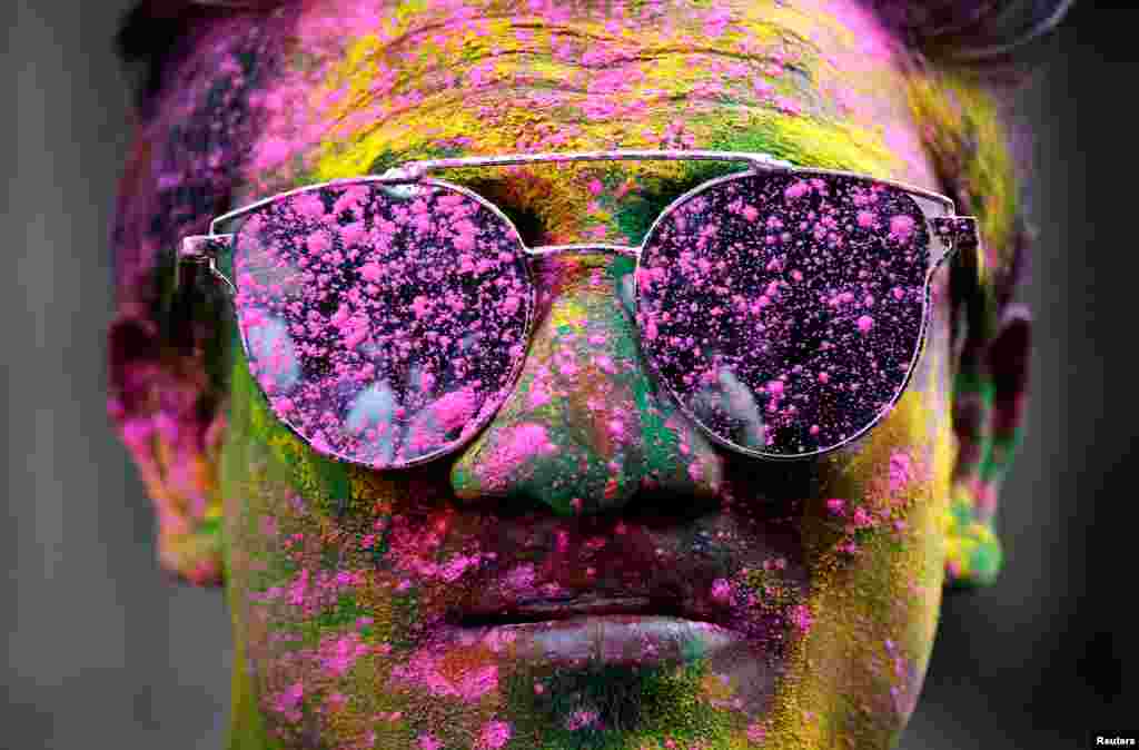 A man smeared in coloured powder poses during Holi celebrations in Kolkata, India.