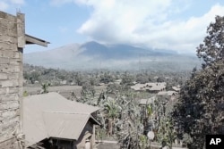 Dalam gambar yang diambil dari video AP, Gunung Lewotobi Laki-Laki memuntahkan asap vulkanik, menyelimuti desa yang terdampak letusannya di Flores Timur, 5 November 2024. (AP)