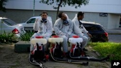 Una brigada que fumiga para combatir el dengue en medio de un aumento de casos en todo el país descansa en un parque donde están fumigando en Buenos Aires, Argentina, el martes 26 de marzo de 2024. (Foto AP/Natacha Pisarenko)