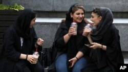 Tahran'da bir AVM'de oturan genç kızlar