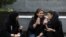 In this July 2, 2019 photo, young women sit outside a shopping mall in northern Tehran.