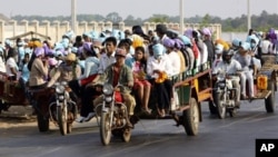 Cambodian garment factory workers travel together in motor carts to get home from work at the Sala Lek Pram village, Kampong Chhnang province.