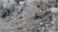 A civilian collects tree branches amid the rubble of a damaged site in the rebel-held besieged Qadi Askar neighborhood of Aleppo, Syria, Nov.  24, 2016. 