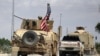 FILE - The U.S. flag flutters on a military vehicle in Manbij countryside, Syria, May 12, 2018.