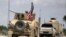 FILE - The U.S. flag flutters on a military vehicle in Manbij countryside, Syria, May 12, 2018.