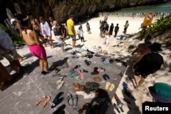 Tourists enter the beach for an hour-long visit, where swimming is forbidden and people are only allowed to enter water up to their knees, in Maya Bay at the Phi Phi Island National Park, on Phi Phi Leh Island, Krabi province, Thailand, February 28, 2023.