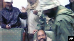 Saif al-Islam Gaddafi sitting with his captors in Obari airport November 19, 2011. Saif al-Islam has been captured in Libya's southern desert, scared and with only a handful of supporters