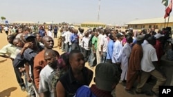 People wait in line at a registration center in Abuja, 15 Jan 2011.