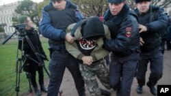 Polisi menangkap seorang demonstran dalam aksi protes oposisi di St.Petersburg, Rusia, Minggu (5/11).
