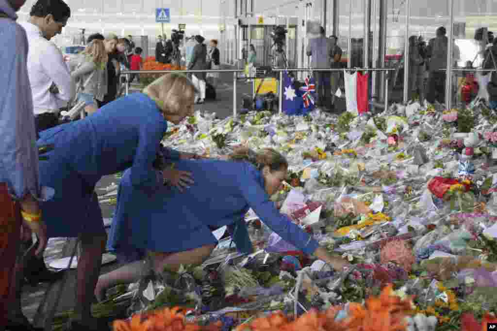 Two KLM cabin crew reach out into a sea of flowers at Schiphol airport in Amsterdam, July 22, 2014. 