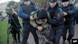 Police officers detain a man during a protest in St.Petersburg, Russia, Nov. 5, 2017.