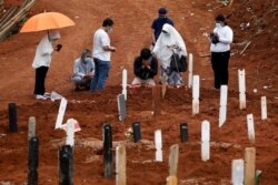 Kerabat berkabung saat pemakaman anggota keluarganya di area pemakaman yang disediakan pemerintah untuk korban Covid-19 di kompleks pemakaman Pondok Ranggon, Jakarta, 24 September 2020. (Foto: Reuters)