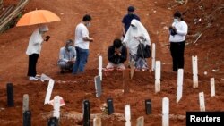 Relatives mourn during the funeral of their family member at the burial area provided by the government for victims of COVID-19 at Pondok Ranggon cemetery complex, as the outbreak continues in Jakarta, Indonesia, Sept. 24, 2020.…