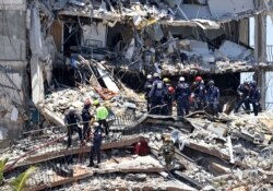 Search and rescue personnel search for survivors in the rubble at the Champlain Towers South in Surfside, Florida, June 27, 2021. (David Santiago/Miami Herald via AP)