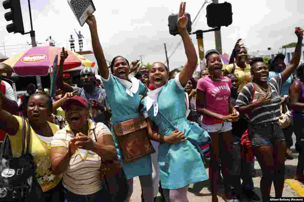 Supporters cheer while watching a broadcast of Jamaica's Shelly-Ann Fraser-Pryce winning the women's 200 metres final during Moscow's IAAF World Athletics Championships, in Kingston August 16, 2013. Fraser-Pryce completed a brilliant world championship sp