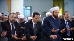 Presiden Suriah Bashar al-Assad (kedua dari kiri) menghadiri sholat Idul Adha di masjid al-Nu'man bin Bashir di Damaskus 4 Oktober 2014.