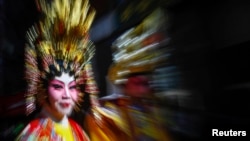 A woman dressed in traditional wear takes part in the 14th annual Chinatown Lunar New Year Parade in New York, February 17, 2013. 