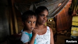 Lankika Dilrukshi, 31, along with her son is pictured inside her house in Thotalanga, Colombo, Sri Lanka, Sept. 9, 2024.