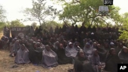 FILE - In this photo taken from video released by Nigeria's Boko Haram terrorist network, May 12, 2014, shows missing girls abducted from the northeastern town of Chibok. 
