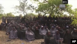 FILE - This file photo taken from video released by Nigeria's Boko Haram terrorist network, May 12, 2014, shows missing girls abducted from the northeastern town of Chibok.