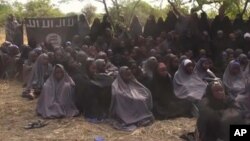 In this file photo taken from video released by Nigeria's Boko Haram terrorist network, May 12, 2014, shows missing girls abducted from the northeastern town of Chibok. A teenage who surrendered before carrying out a suicide bombing attack in northern Cameroon has told authorities she was one of the 276 girls abducted from a Nigerian boarding school by Islamic extremists nearly two years ago, authorities said Saturday, March 26, 2016. (AP Photo)