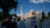 Personas se toman un selfie afuera de la cerra catedral de la era bizantina, Hagia Sophia, una de las principales atracciones turísticas de Estambul. Julio 11 de 2020.