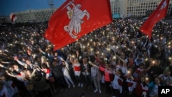 Belarusian opposition supporters light phones lights during a protest rally in front of the government building at Independence Square in Minsk, Belarus, Aug. 22, 2020. 