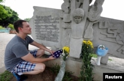 English teacher Derek Davis from the U.S. places a U.S. flag and flowers in memory of the late U.S. Senator John McCain (R-Az.) at the McCain Memorial in Hanoi, Vietnam, Aug. 26, 2018.