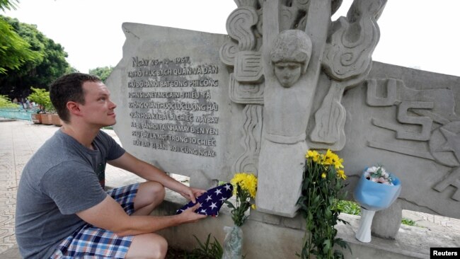 Một công dân Mỹ đặt hoa tưởng nhớ ông McCain tại một địa điểm ở Hà Nội, nơi ông "bị bắt sống" trong Chiến tranh Việt Nam.