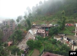 Indian rescuers work on a site after a multistory building collapsed following heavy rains near Kumarhatti, in Himachal Pradesh’s Solan district.