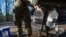 National Guard sergeants fill gallons for a resident at a public water distribution site after a recent bout of cold weather caused large numbers of water outages, some going into their third week, in Jackson, Mississippi, March 4, 2021. 